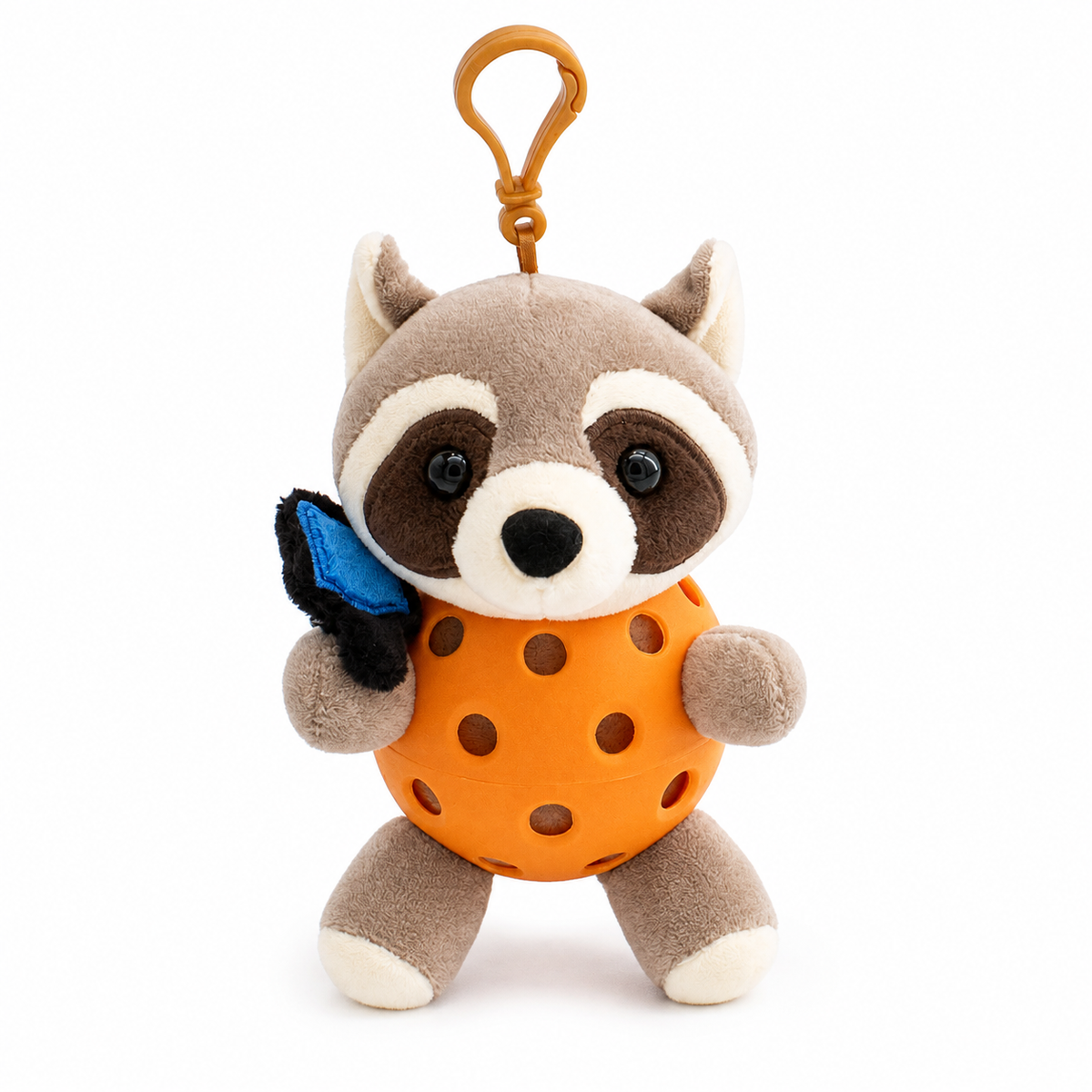 A plush raccoon toy inside an orange pickleball, attached to an orange key ring, photographed on a clean white background.
