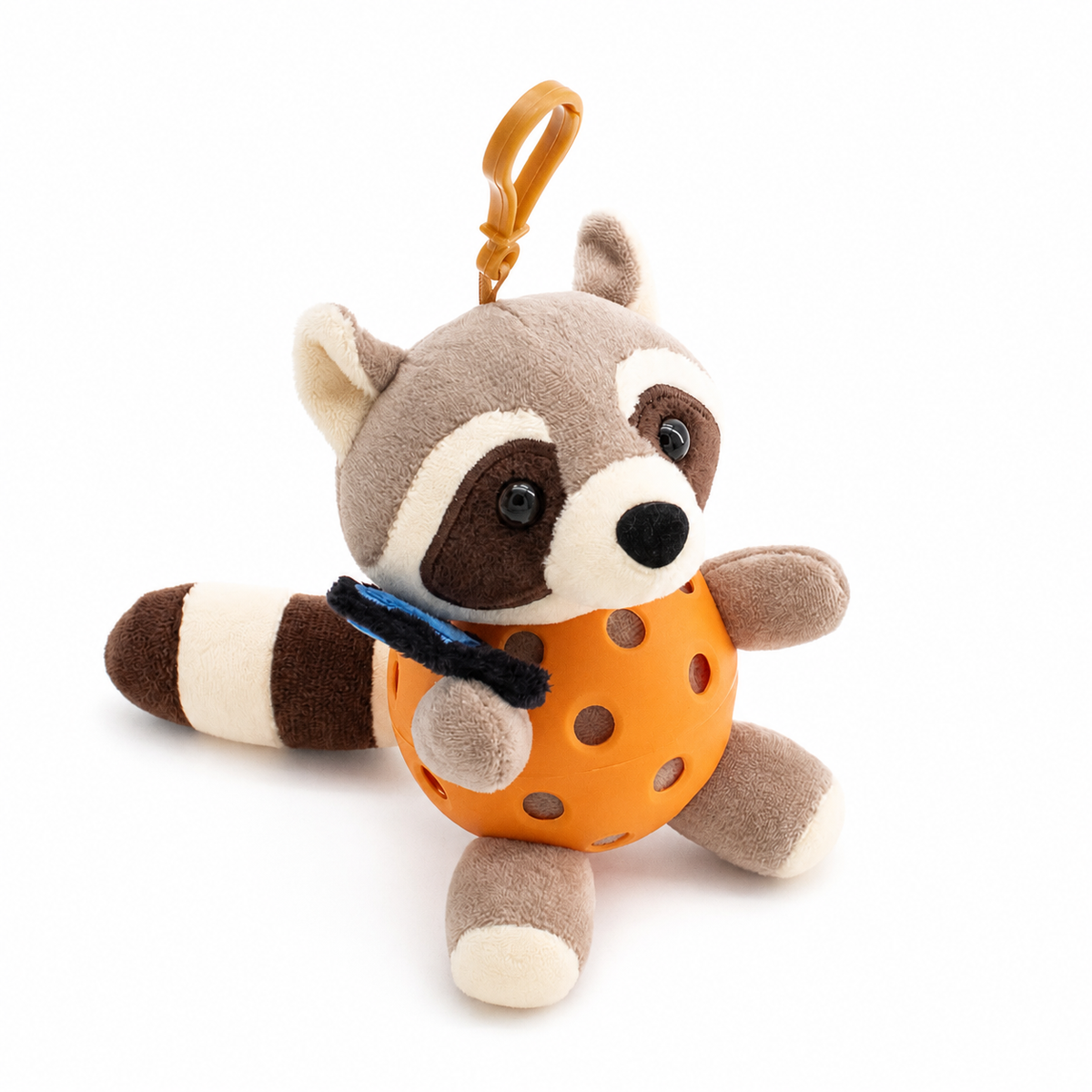 A plush raccoon toy inside an orange pickleball, attached to an orange key ring, photographed on a clean white background.