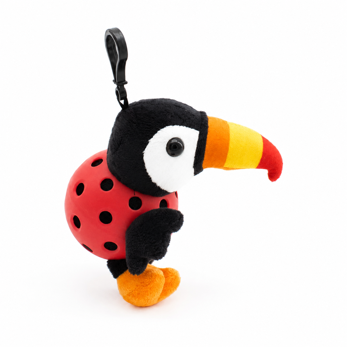 A plush toucan toy inside a red pickleball, attached to a black key ring, photographed on a clean white background.